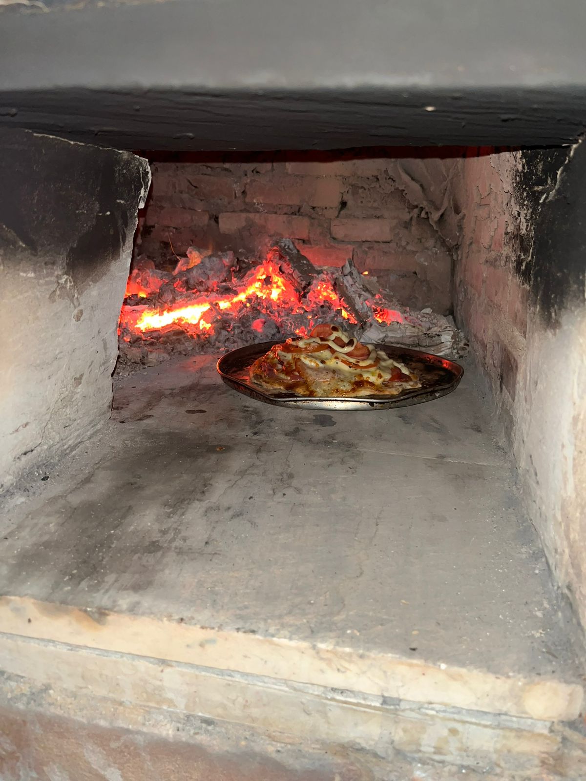 Forno a lenha com pizza assando